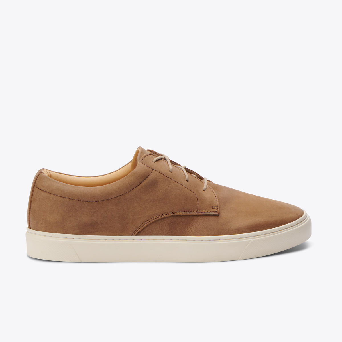 Single tobacco brown leather sneaker with tan laces and a thick white rubber sole shown from a side profile.