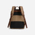 Rear view of a tan waxed canvas backpack with brown leather trim, padded shoulder straps, and black mesh back panels.