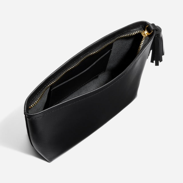 Black leather Petra Pouch with a gold zipper, interior pocket, and tassel detail on a white background.