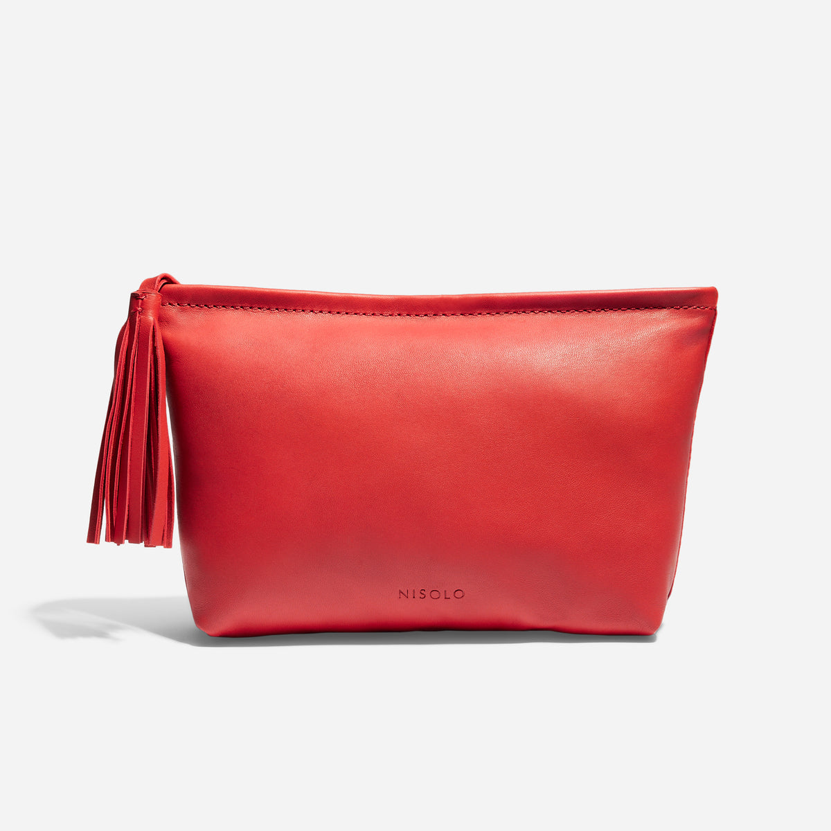 Red leather pouch with a tassel zipper pull and the NISOLO brand name embossed on the front.
