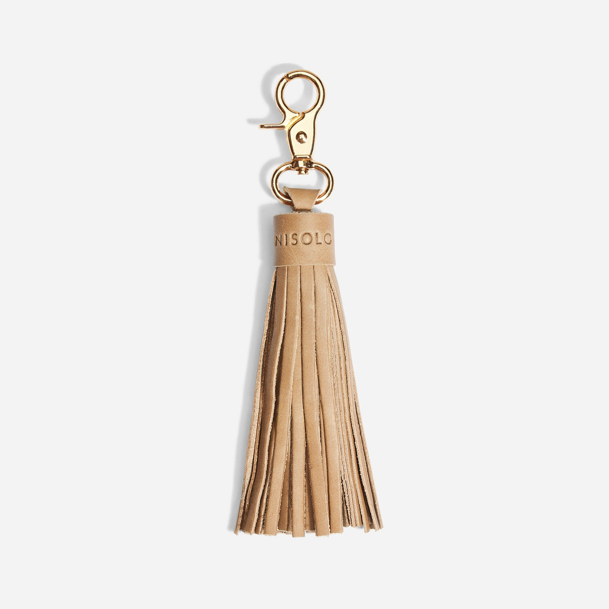 Single almond leather tassel bag charm with a gold metal clasp and NISOLO embossed on the top band.