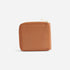 Square caramel leather Remi Zip Wallet with a gold-tone metal zipper on a white background.