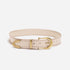 Cream leather belt with whipstitch edges and a gold-tone metal buckle and tip, coiled on a white background.