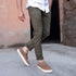 Pair of tobacco brown leather Diego Everyday Sneakers with white soles and tan laces worn with olive pants.