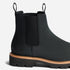 Side view of a black leather Chelsea boot with elastic side panels, pull tabs, and a lugged sole with tan welt stitching.