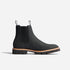 Single black leather Chelsea boot with elastic side panels, pull tabs, and a lugged sole with tan welt.