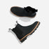 Pair of black leather Chelsea boots with tan midsoles and lugged outsoles, shown from side and top views on a white surface.