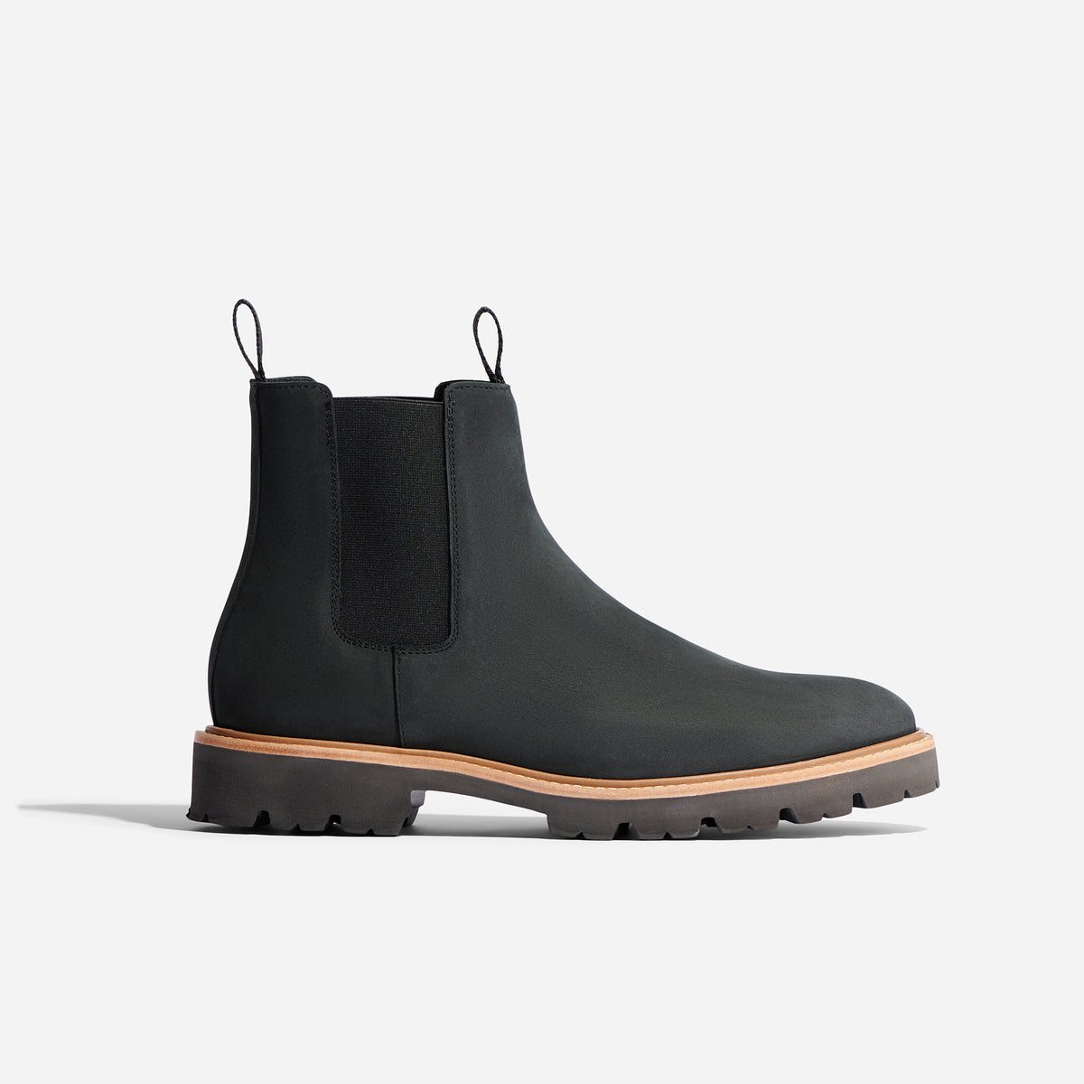 Single black Chelsea boot with elastic side panels, pull tabs, and a lugged sole with a tan welt.