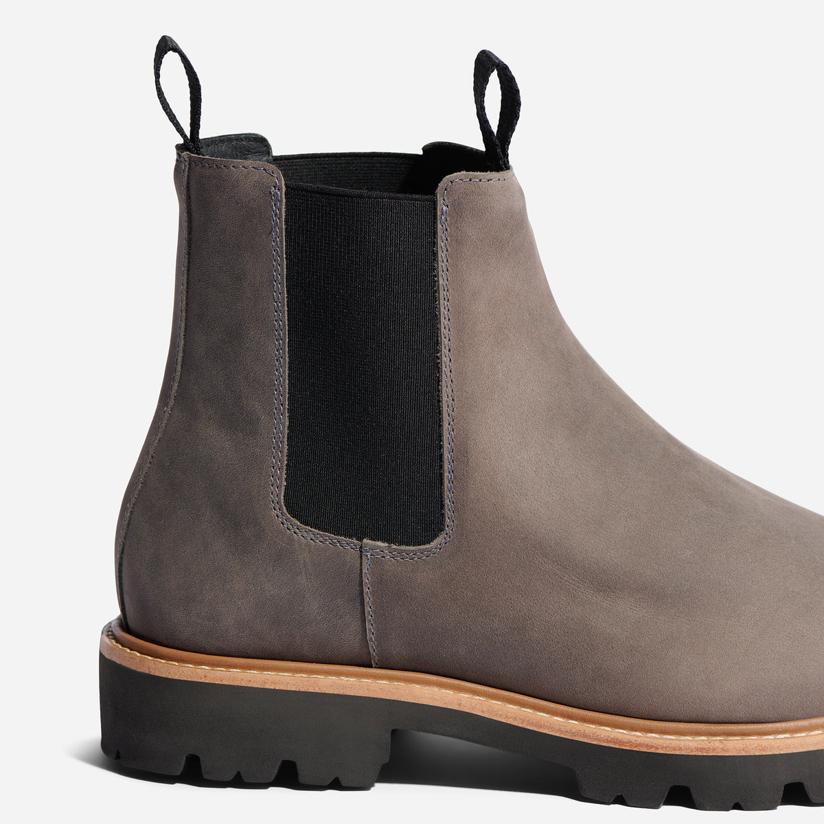 One grey leather Chelsea boot with black elastic side panels, pull tabs, and a lugged rubber sole.
