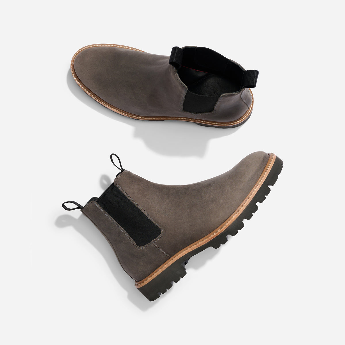Two grey leather Chelsea boots with black elastic side panels and lugged soles, shown from top and side angles.