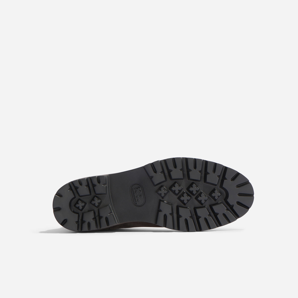 Bottom view of a black lugged rubber boot sole featuring a textured tread pattern and an oval logo in the center.