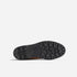 Bottom view of a brown boot showing a black lugged rubber sole with a textured tread pattern and the Nisolo logo.