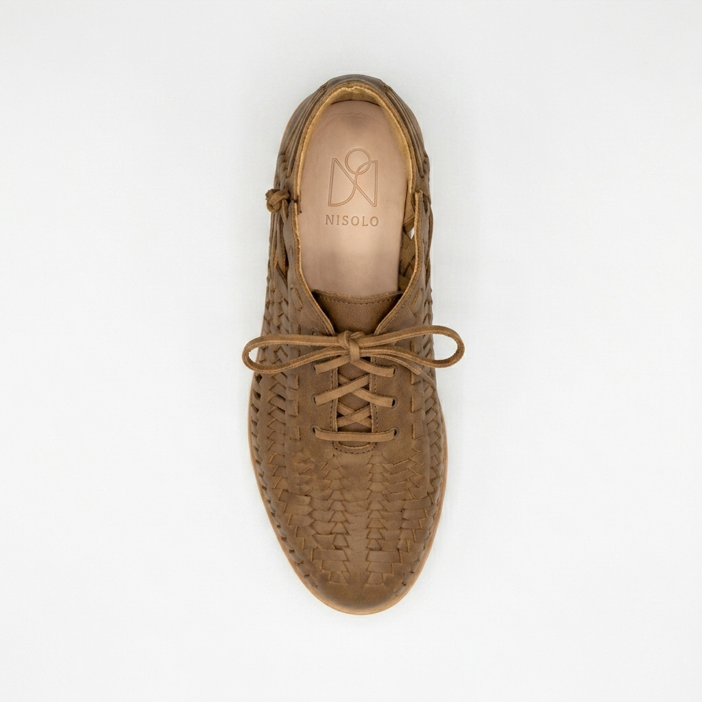 Single brown woven leather boot with laces, top view on white background. NISOLO brand logo printed on the inner heel.