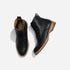 Pair of black leather lace-up boots with tan soles, shown from a top-down bird's-eye view on a white background.