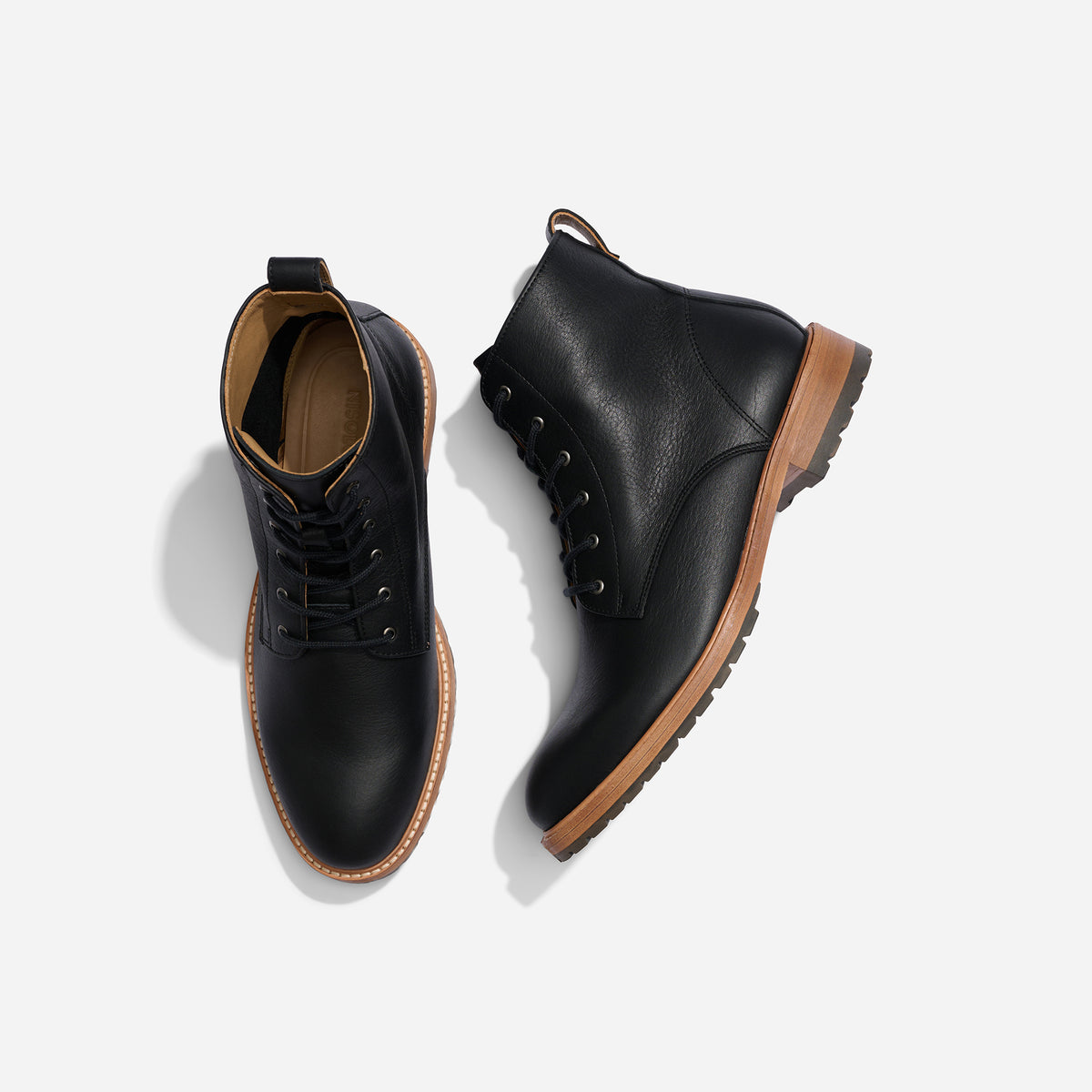 Pair of black leather lace-up boots with tan soles, shown from a top-down bird's-eye view on a white background.