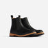 Pair of black leather Chelsea boots with tan wood-look midsoles and black lug soles on a white background.