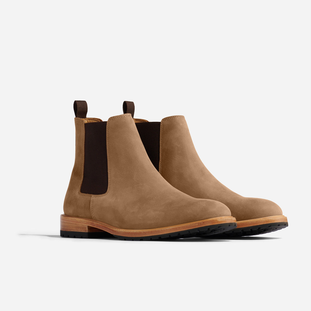 Pair of tobacco brown leather Chelsea boots with dark elastic side panels and pull tabs on a white background.