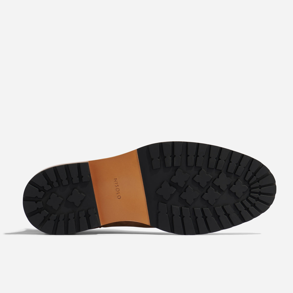Bottom view of a brown leather boot featuring a black lugged rubber sole with the NISOLO brand name printed on the arch.