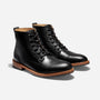 Pair of black leather cap toe boots with black laces and brown soles, angled on a white background.