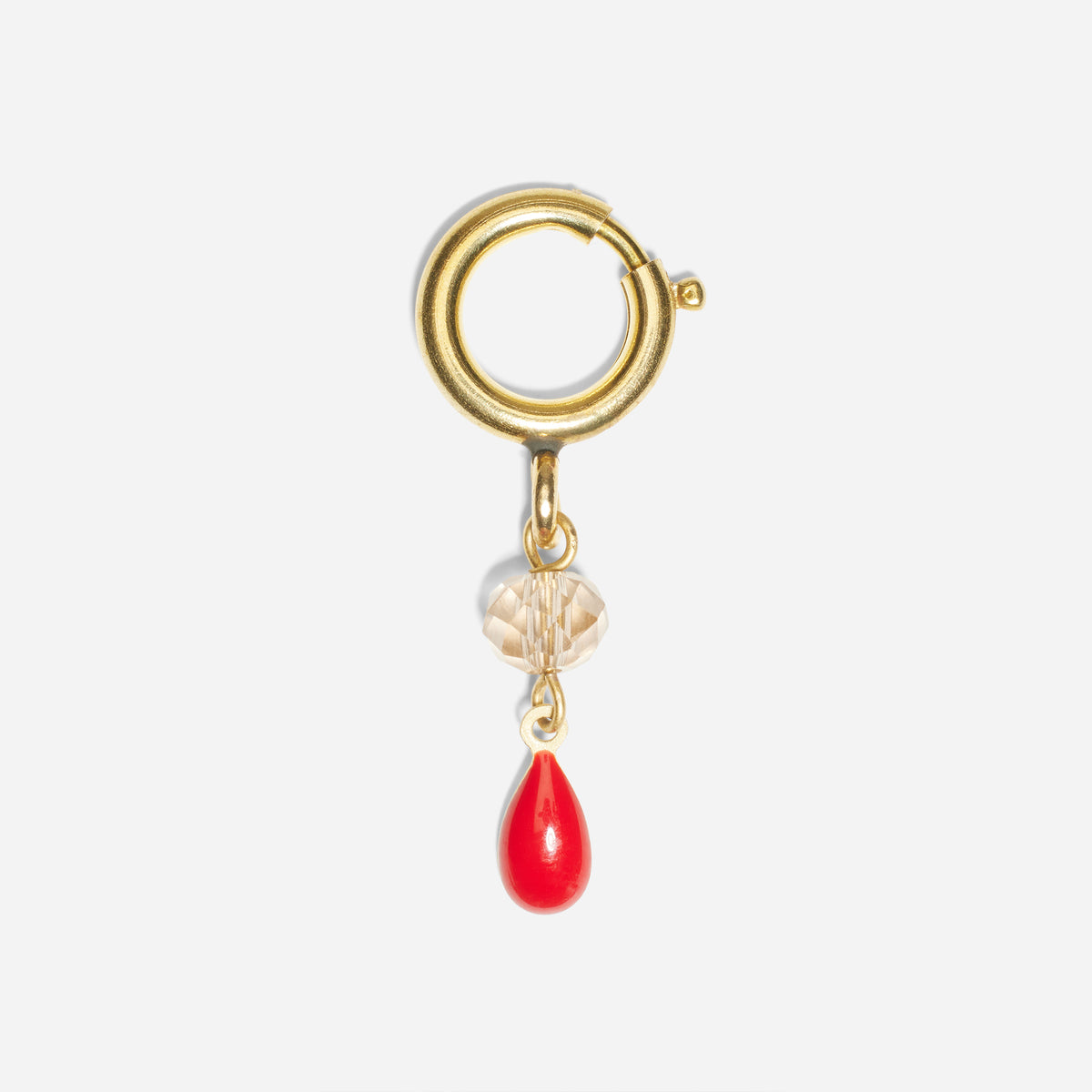Gold metal ring shoe charm with a clear faceted bead and a red teardrop pendant.