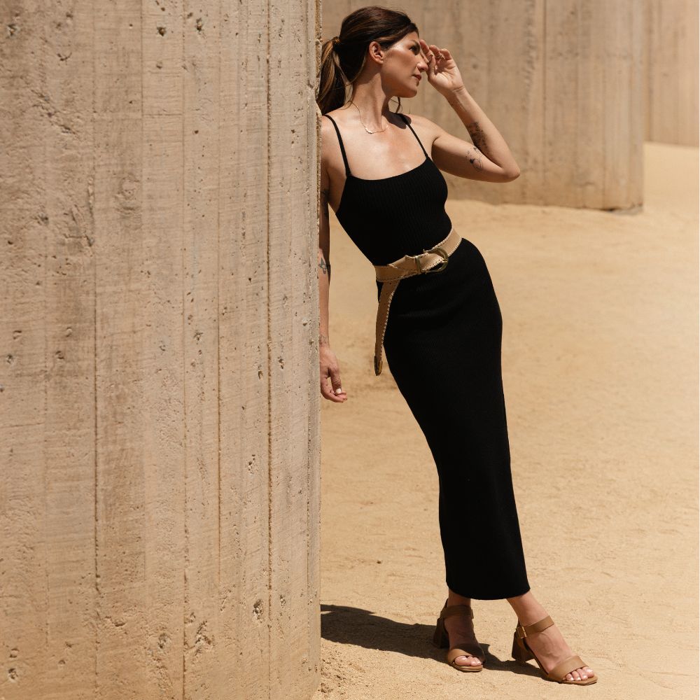 Woman in a black dress wearing a tan Bonnie Belt Whipstitch Pearl leather belt with a round buckle.