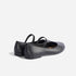 Pair of black leather Bea Go-To Mary Jane flats with elastic straps, shown from a rear three-quarter angle.