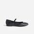 Single black leather Mary Jane flat with a round toe and thin elastic bridge strap shown in profile.