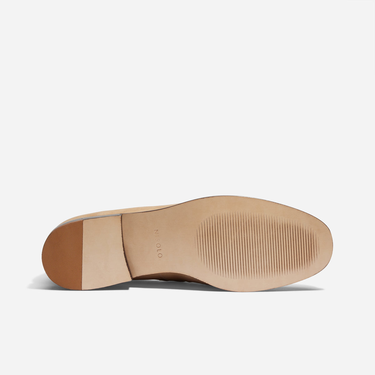 Tan leather loafer sole with NISOLO printed on the arch and a textured rubber grip on the forefoot and heel.