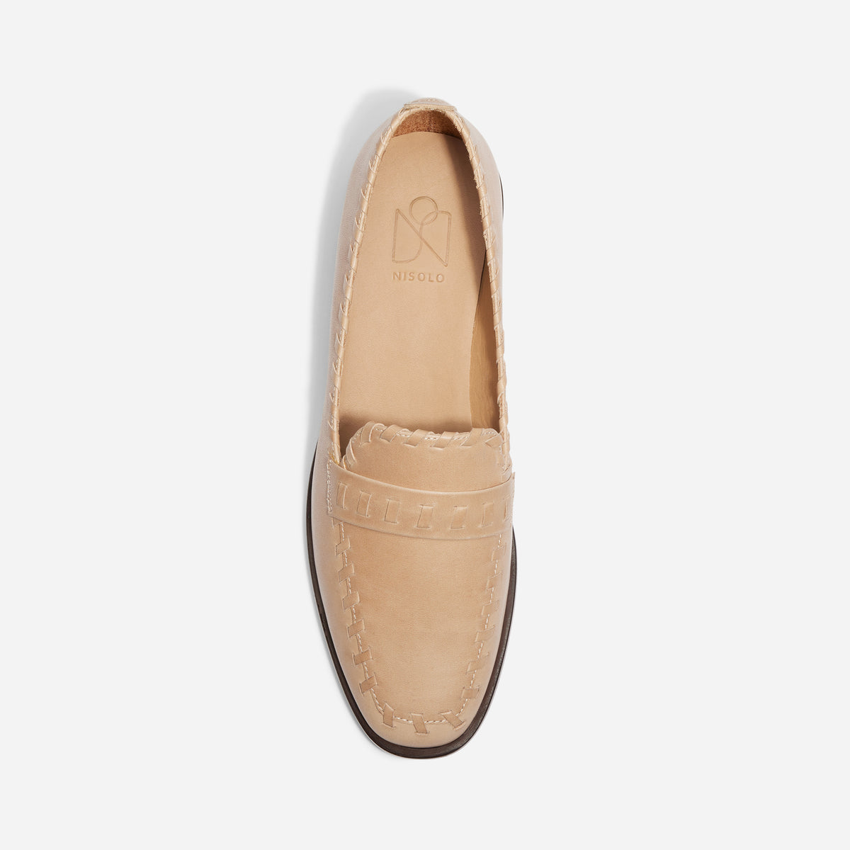 Single tan leather loafer with whipstitch detailing and NISOLO printed on the inner sole, top-down view.