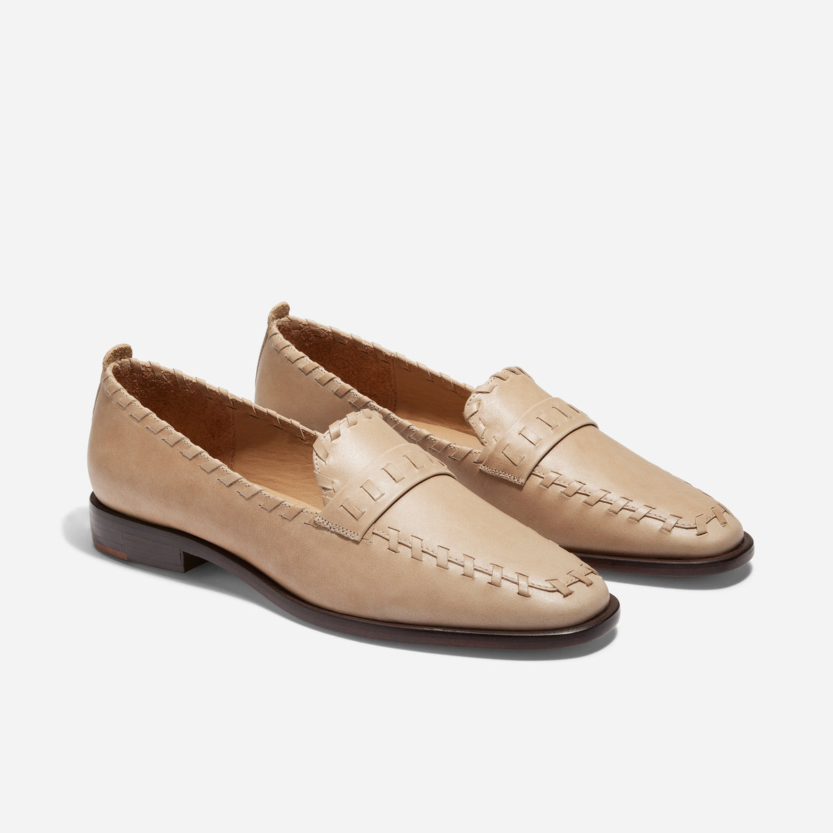 Pair of almond beige leather Lidia Whipstitch Loafers with square toes and decorative stitching on a white background.