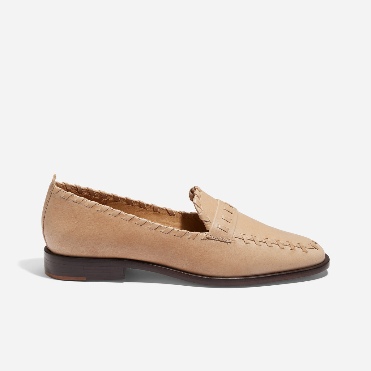 Single almond leather loafer with whipstitch detailing along the edges and a dark brown sole.