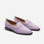 Pair of lilac suede loafers with whipstitch detailing and dark brown soles on a white background.