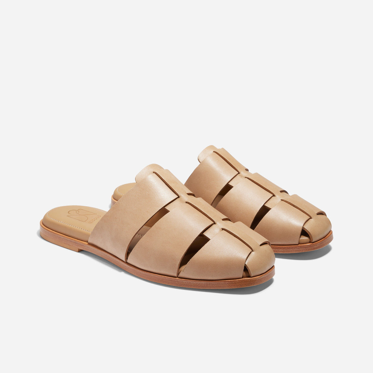 Pair of tan leather Anita Fisherman Mules with woven straps and open heels on a white background.