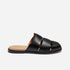Single black leather fisherman mule with a tan insole and woven strap design, shown from a side profile on a white backgro...