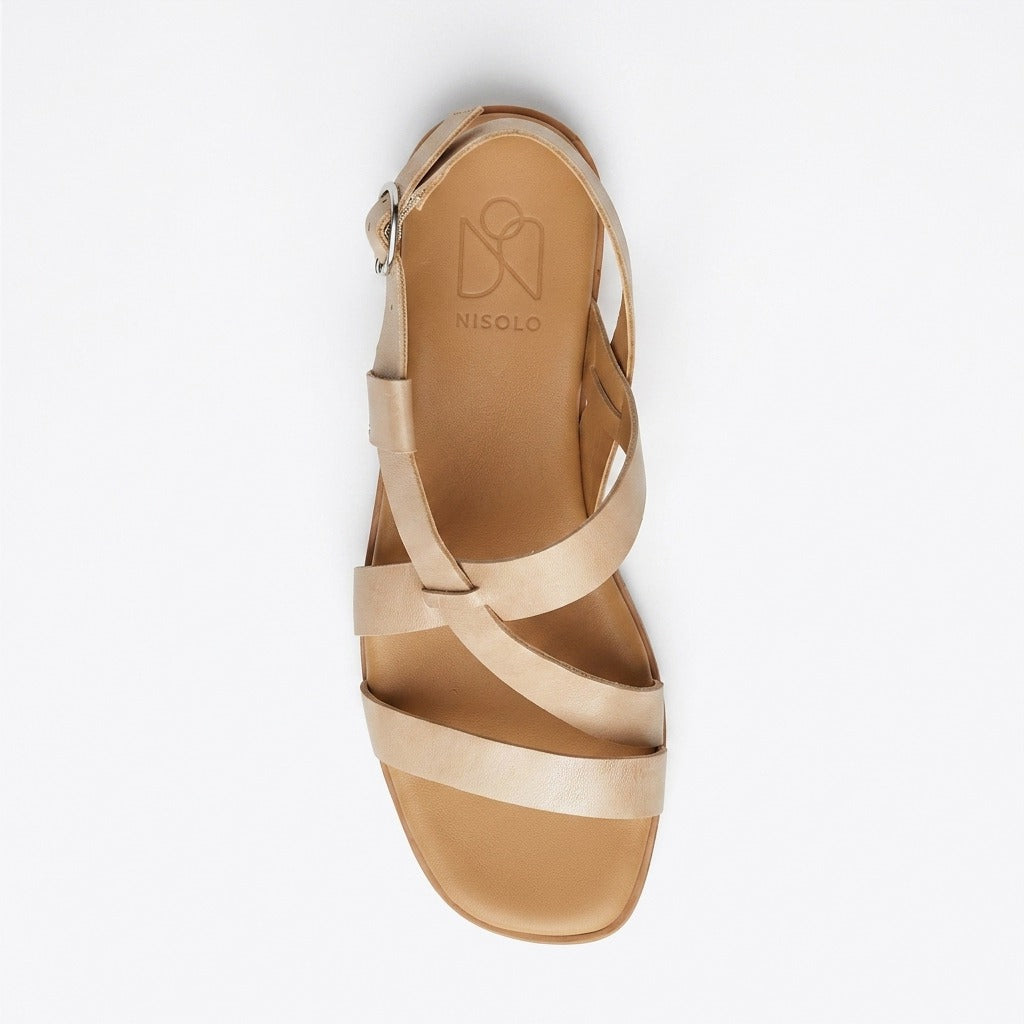 Single tan leather strappy sandal with a buckle heel strap and NISOLO printed on the footbed.
