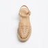 Single almond leather T-strap huarache sandal with woven toe, jute espadrille sole, and Nisolo logo on the heel.