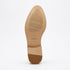 Tan rubber sole of a shoe with NISOLO and size 7 printed on the bottom.