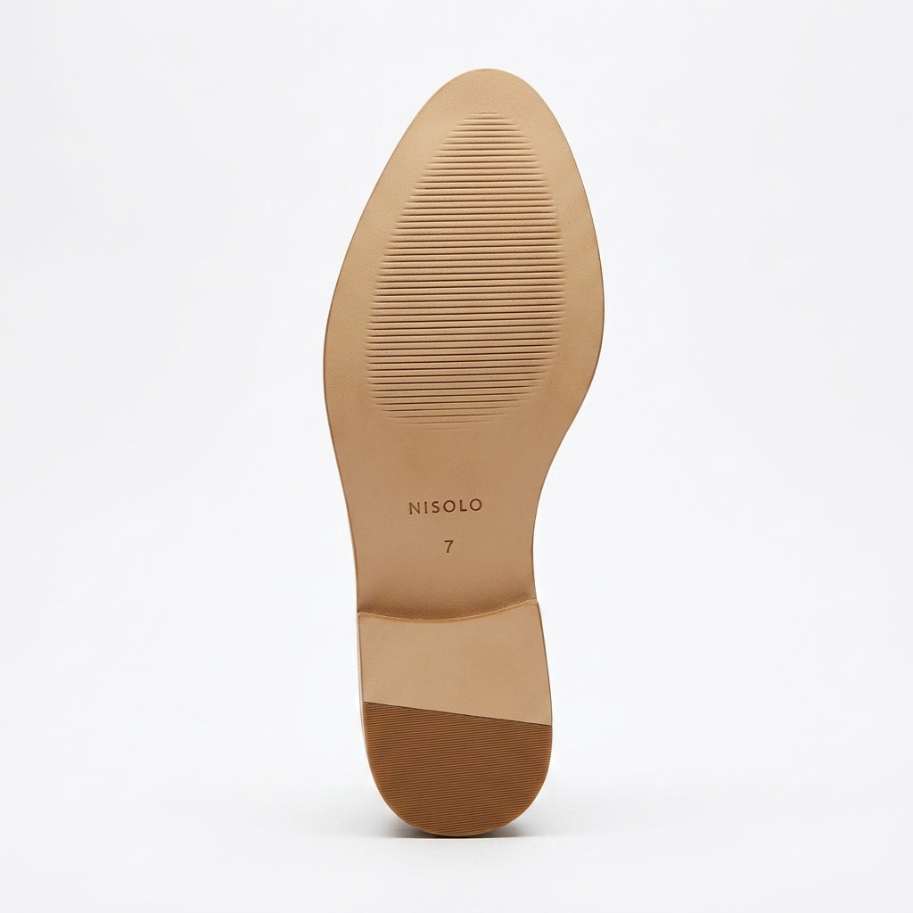 Tan rubber sole of a shoe with NISOLO and size 7 printed on the bottom.