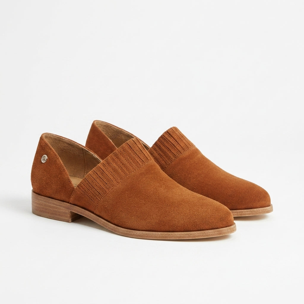 Pair of terracotta suede slip-on oxford shoes with ribbed elastic side panels and low wooden heels.