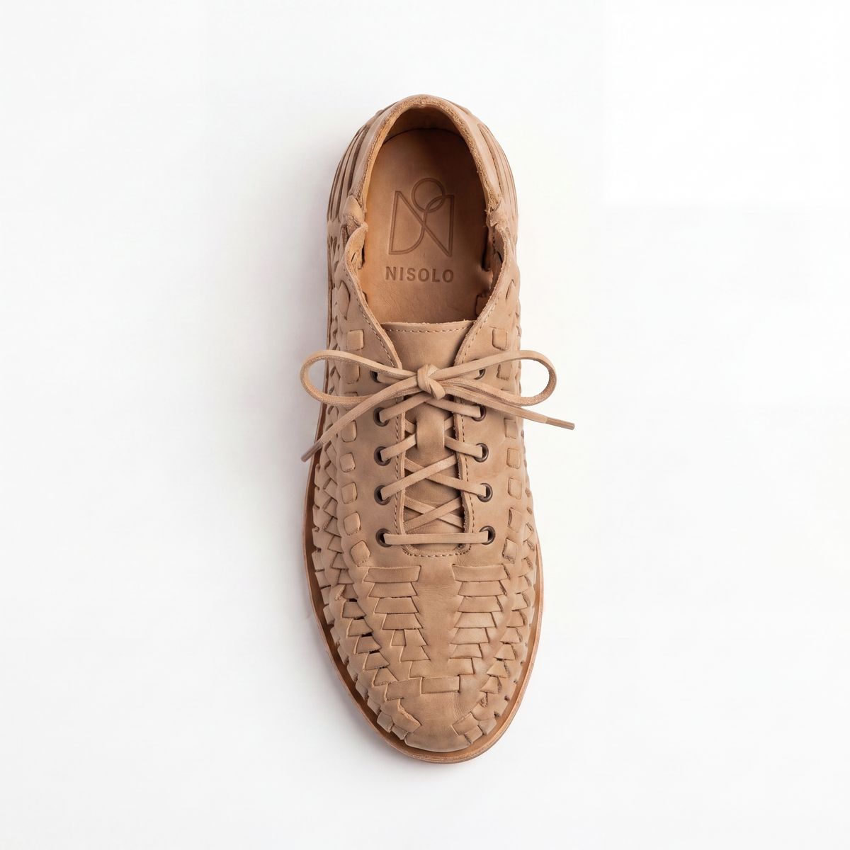 Single tan woven leather bootie with laces and NISOLO printed on the inner sole, viewed from above on a white background.