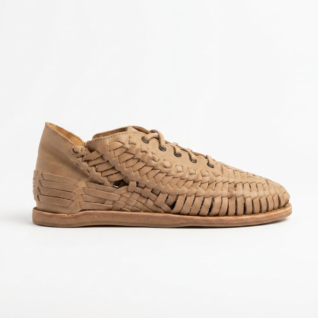 Single tan woven leather bootie with laces and a flat sole shown from a side profile against a white background.