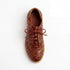 Single brown woven leather bootie with laces and NISOLO printed on the inner sole, viewed from above on a white background.