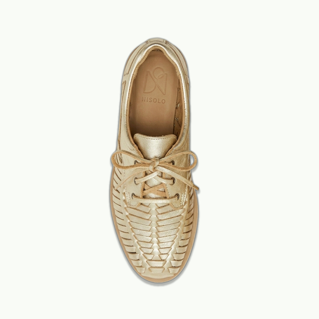 A single metallic gold boat shoe with a textured, woven-like upper and matching laces, shown from a top-down view on a light off-white background. The brand name 'MISOLO' is visible on the inner sole.
