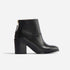 Single black leather ankle boot with a block heel and rear gold zipper shown in profile on a white background.
