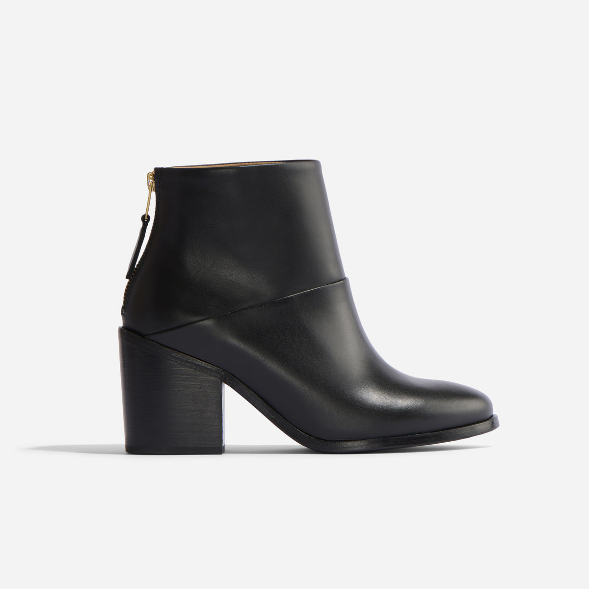 Single black leather ankle boot with a block heel and rear gold zipper shown in profile on a white background.