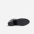 Bottom view of a black leather boot showing a textured rubber sole and block heel with the NISOLO logo.