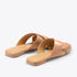 Pair of almond leather slide sandals with crisscross straps and NISOLO printed on the footbed.