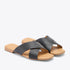 Pair of black leather slide sandals with crisscross straps and tan soles featuring the NISOLO logo.