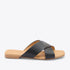 Single black leather slide sandal with crisscross straps and a tan footbed featuring the NISOLO brand name.
