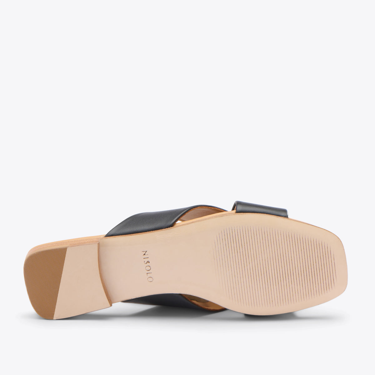 Bottom view of a black leather slide sandal with a tan sole and NISOLO printed on the arch.